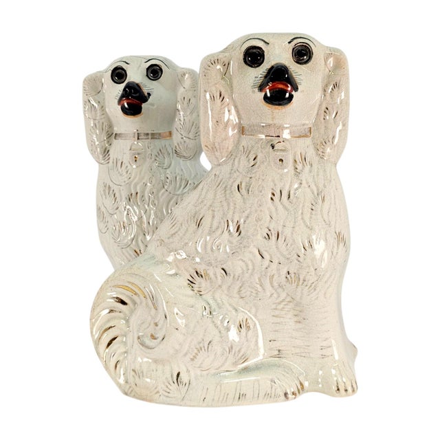 A matched pair of late nineteenth-century Staffordshire spaniel mantel figures, England, circa 1870–1890, modelled as...