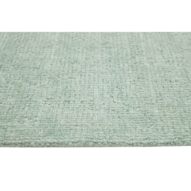 This contemporary Indian hand-knotted wool rug is thoughtfully crafted by skilled artisans and boasts a minimalist design....