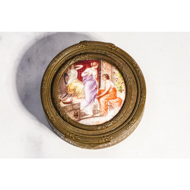 A beautifully refined example of 19th-century decorative craftsmanship, this antique round metal trinket or jewelry box...
