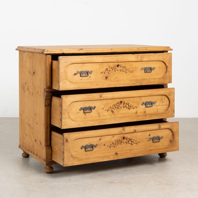 Antique pine chest of three drawers resting on bun feet. Note the applied decorative carving along paneled drawer fronts...