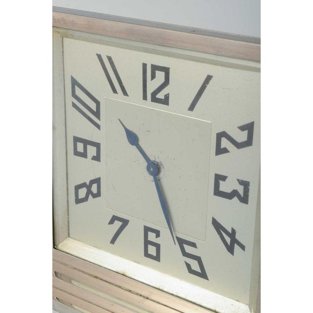 Art Deco silver-plated mantel clock. Elegant square-shaped manuel clock on a rectangular base with geometric Art Deco...
