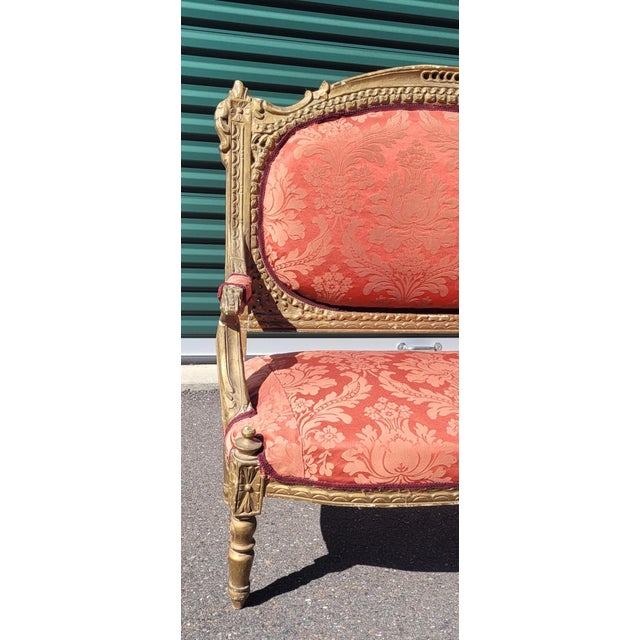 Antique Imperial style red damask French settee. Features newer red damask upholstery guiltwood and plaster frame carved...