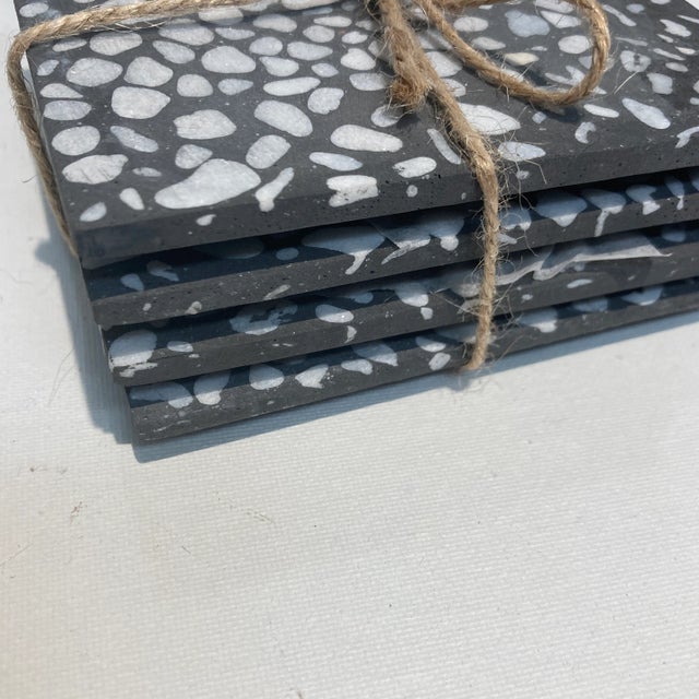 Square shape, set of four white set into gray coasters.