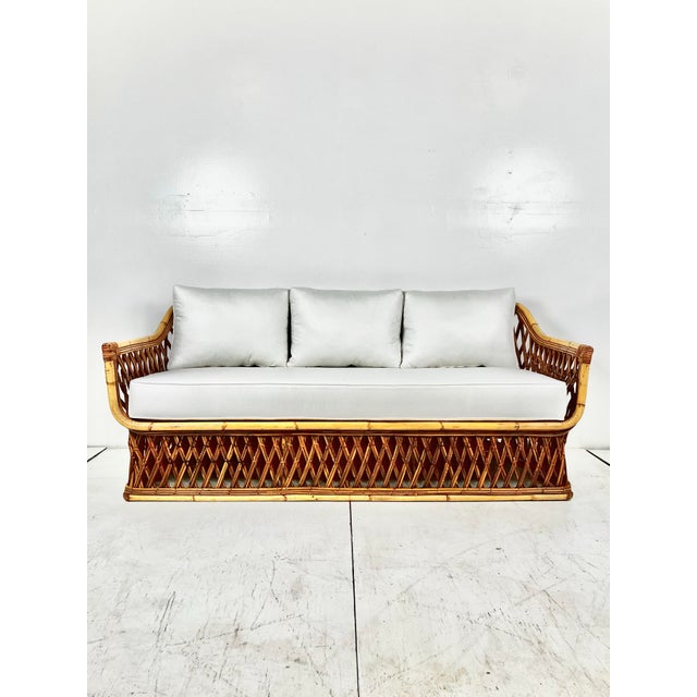 Vintage woven pencil reed rattan sofa. Woven pencil reed base with curved frame around removable bench cushion. Beautiful...