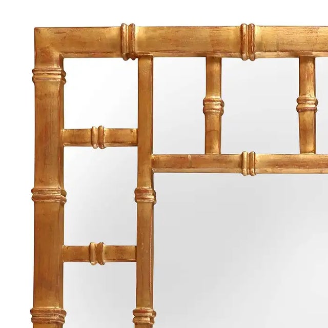 A striking giltwood mirror with a faux bamboo frame, echoing the timeless charm of chinoiserie design. The rich gold...
