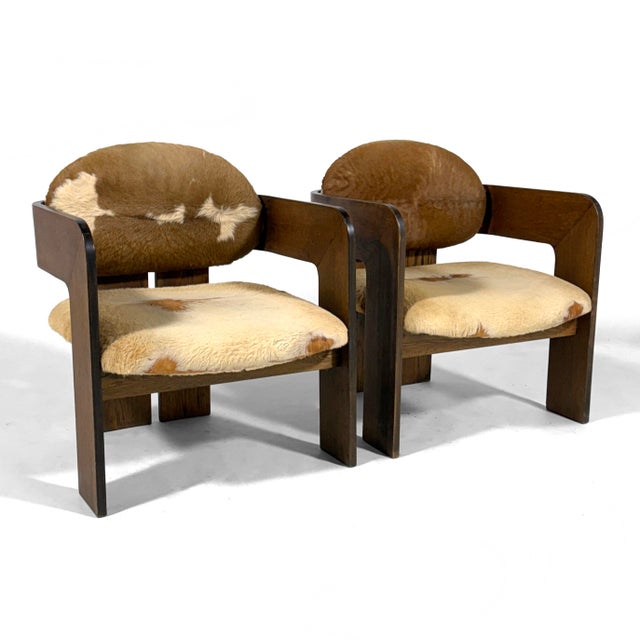 This pair of rare Italian lounge chairs are simply sublime. The dark wood external frames support the seat and back...