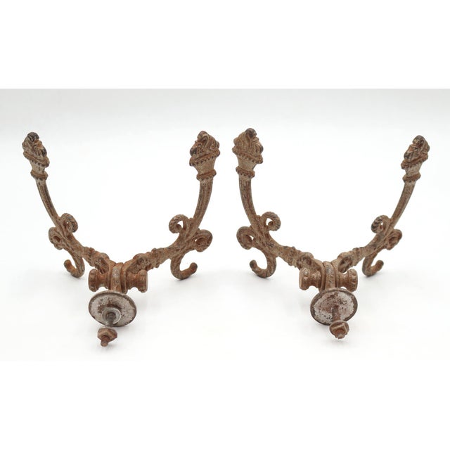 Victorian style hall tree hooks made of cast iron with a distressed tan paint finish. There are screws attached to the...
