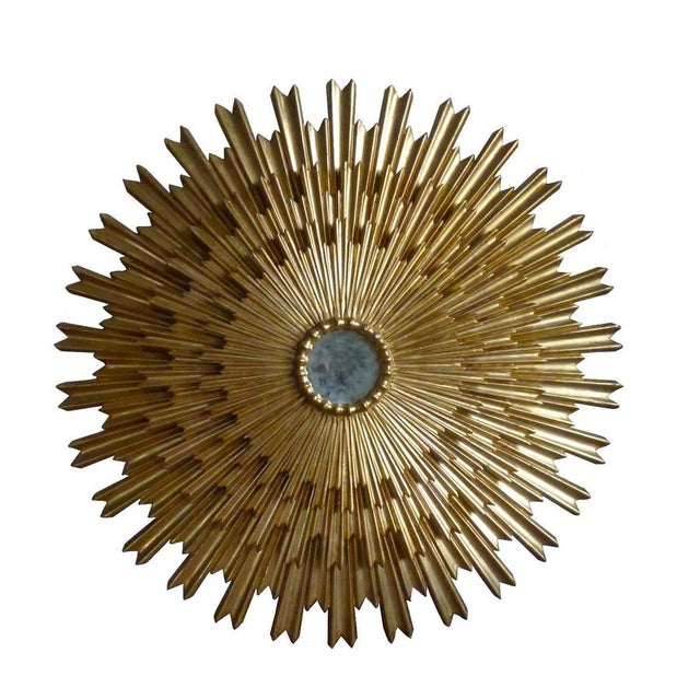 Huge beautiful three tiered sunburst mirror, with a round mirrored glass center in moulded frame. Gold leaf polished on...