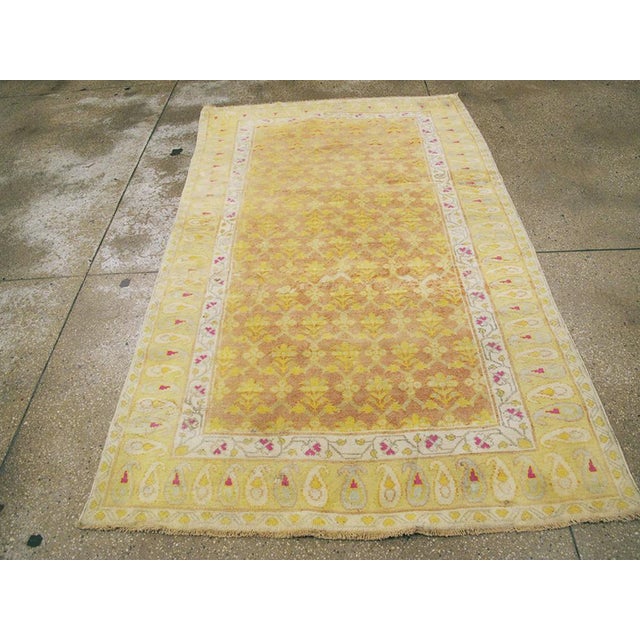 A vintage Indian Cotton Agra rug. A Mughal style lattice displays simple yellow palmettes on the medium brown, variegated...