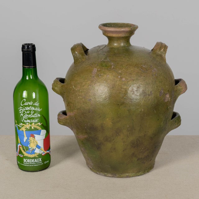 A 19th Century French green glazed pottery jug with ovoid form, short flared neck and looped handles. Beautiful rustic...