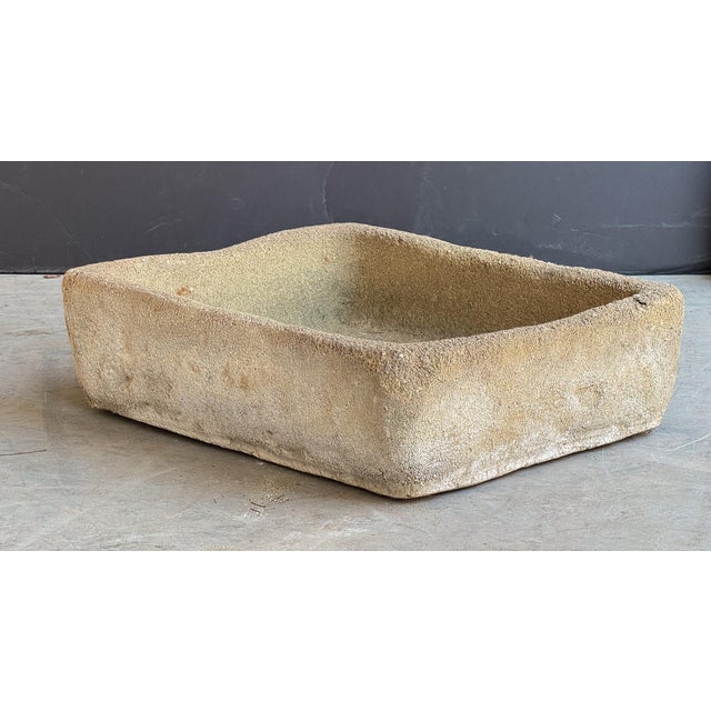 A rustic English garden sink or trough of composition stone, featuring a walled rectangular body with two holes in the...