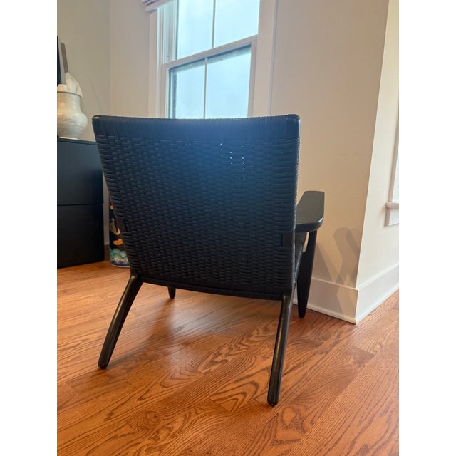 Authentic Hans J. Wegner CH25 lounge chairs manufactured by Carl Hansen & Søn in black oak with black woven paper cord....