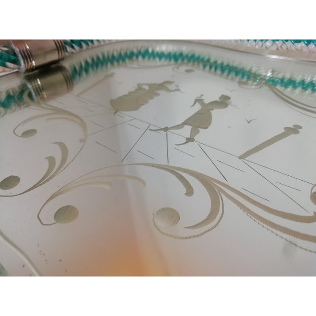 Beautiful tray with a mirrored glass base and a handcrafted rope-like glass edge. The top features a genre scene engraved...