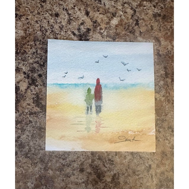This gentle seaside painting captures two figures strolling along the shoreline as birds glide overhead. Soft blues and...