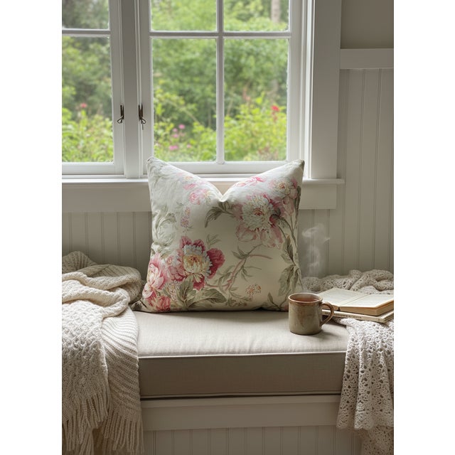 This pillow features a classic, romantic floral design with pink peonies, green foliage and berry tones on a light tan...