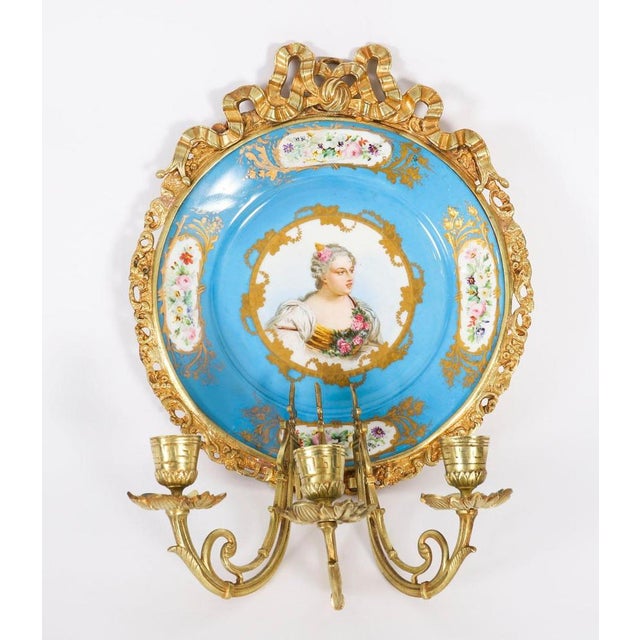 This is a stunning antique pair of sevres porcelain and ormolu mounted wall lights painted with the marquise de pompadour...
