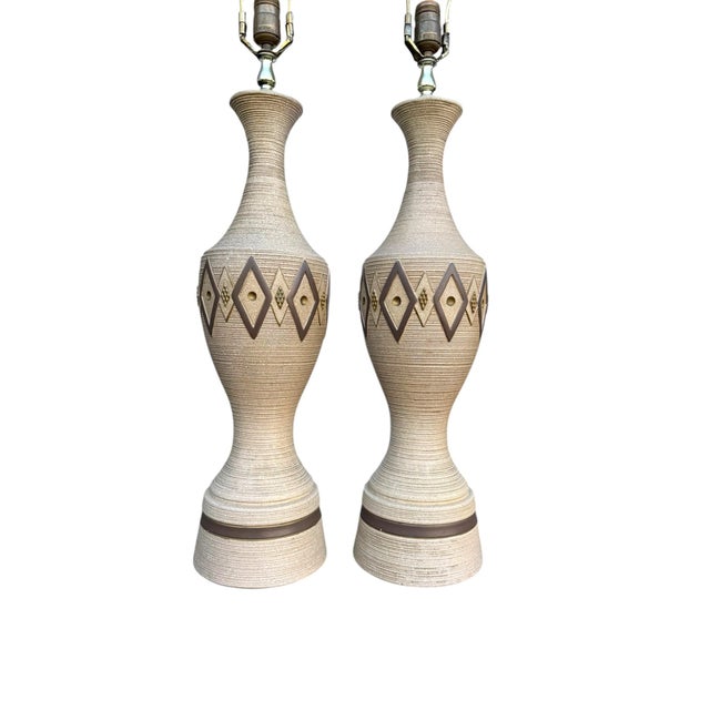 A beautiful pair of vintage mid‑century chalkware lamps, featuring soft neutral tones and a sculptural vertical ribbed...