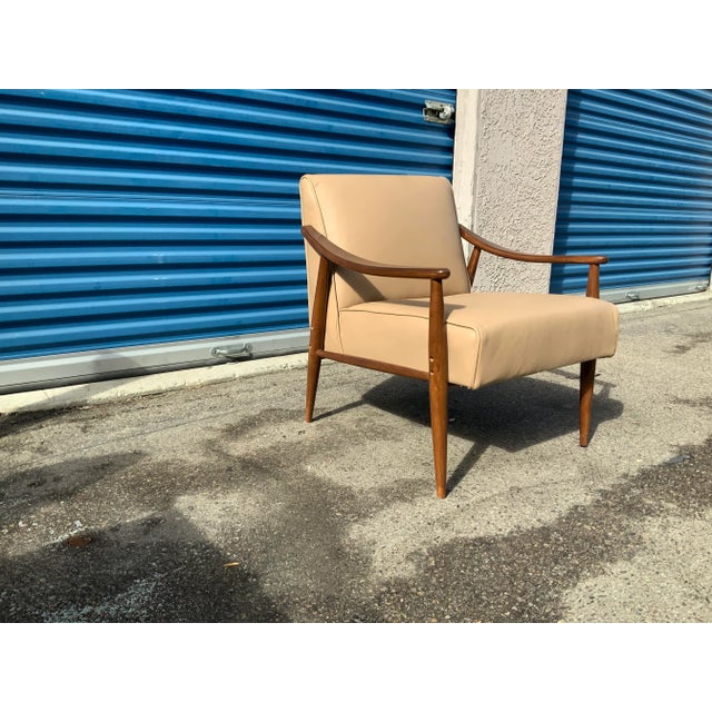 Mid century style lounge chair in tan leather. The chair is done in a an leather newly upholstered and refinished. The...