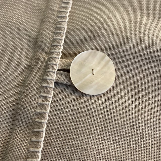 Linen pillow cover with a capiz shell button and white contrast stitching