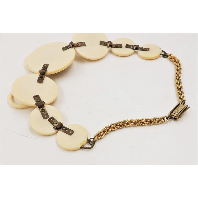 This is part of Chairish’s Costume Jewelry assortment. 1970s goldtone and ivory Lucite round disks and doorknocker style...