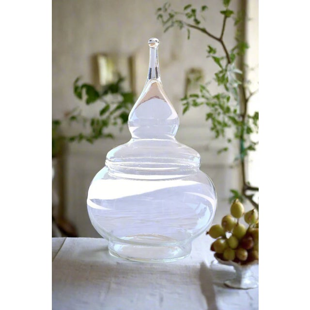 VINTAGE GLASS APOTHECARY JAR Era: 1930s Style: Traditional Pharmaceutical/General Store Origin: Likely American OVERVIEW:...