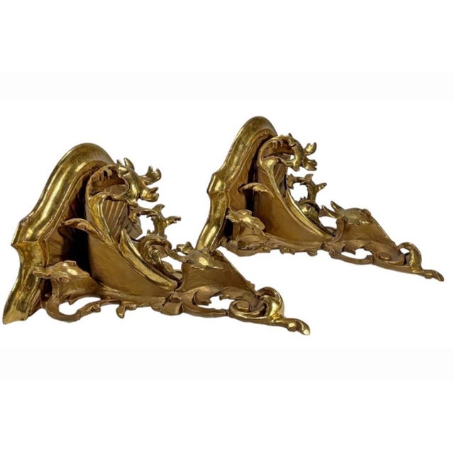 Pair of Italian Baroque-style carved gilt wood wall shelves with scrolling foliate and shell motifs, decorated in a gold...
