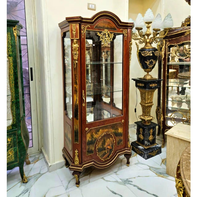 Bring timeless French elegance into your home with this extraordinary hand-painted curio cabinet, featuring glass display...