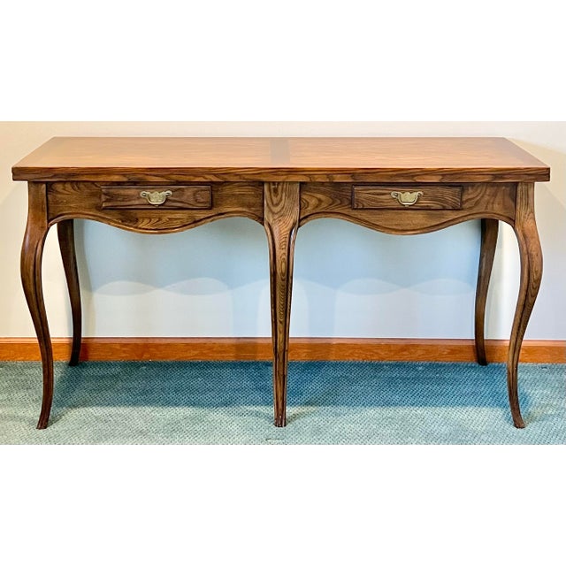 Milling Road French country flip top console table by Baker Furniture. Standing on cabriolet legs this table can adapt to...