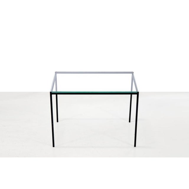 Minimalist black metal side table with a thick glass top from the 1970s. The table is 36 cm high by 50 cm wide and 35 cm...