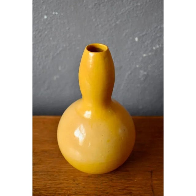 This large gourd vase, produced for the Parisian department store "Le Printemps," features a superb, bright, glossy yellow...