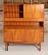 A midcentury teak drinks cabinet/highboard made in teak with a cupboard to the base, open shelving above, two drawers and...