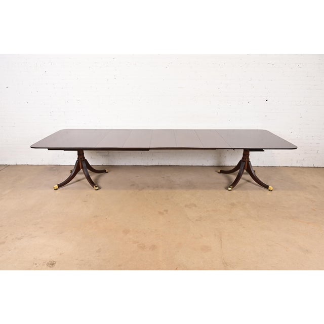 An exceptional Georgian or Regency style double pedestal extension dining table In the manner of Baker Furniture USA,...
