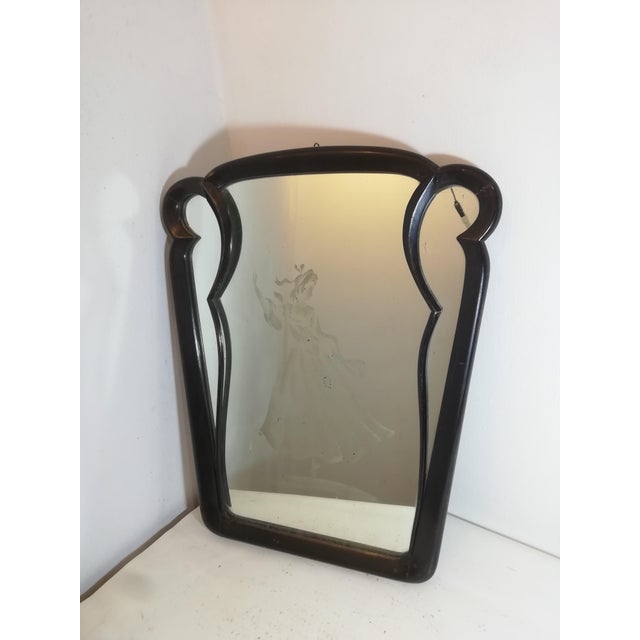 Beautiful Art Deco mirror with an ebony-effect wood frame. Attributable to Gio Ponti's design. The soft and refined shapes...