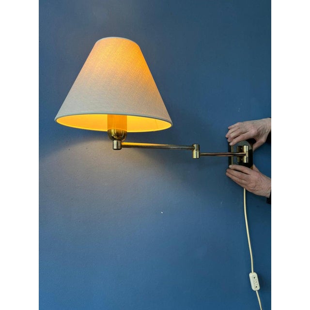 Hollywood Regency swing arm wall lamp withe golden frame and beige shade. The length and position of the lamp can easily...