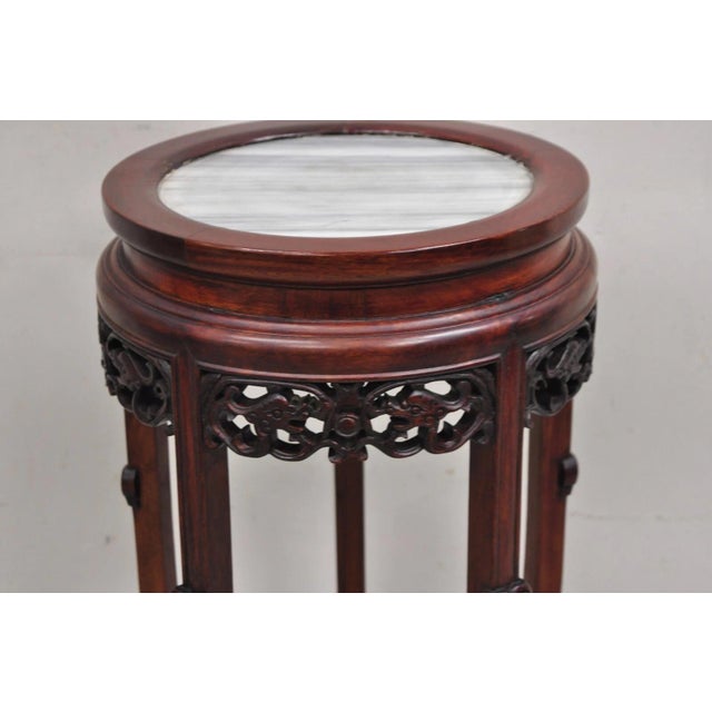 Vintage Chinoiserie Chinese Carved Hardwood Marble Top Pedestal Plant Stand with Floral Carved Details. Circa Mid 20th...