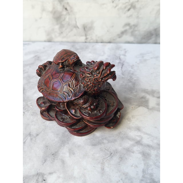 Japanese netsuke carved out of wood with a reddish stained finish. In East Asian art and mythology, dragons and turtles...