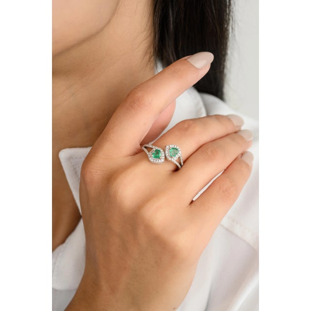 This authentic engagement ring features a captivating heart-cut emerald, complemented by sparkling diamonds in a wrap-...