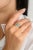 This authentic engagement ring features a captivating heart-cut emerald, complemented by sparkling diamonds in a wrap-...