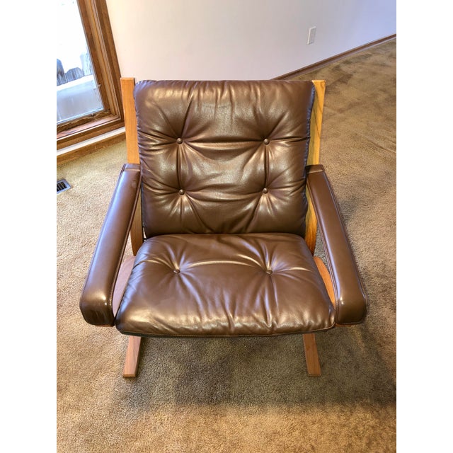 Two authentic Ingmar Relling Siesta armchairs with leather cushions and teak frames. The chair frames, frame fabric, and...