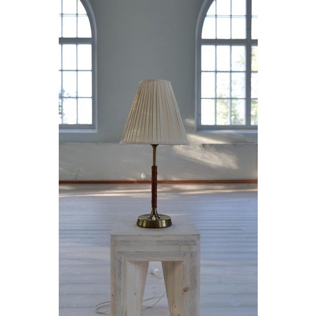 This elegant table was made in the 1950s by the Swedish Company Ewå. Brass base and leather rod with a typical shade from...