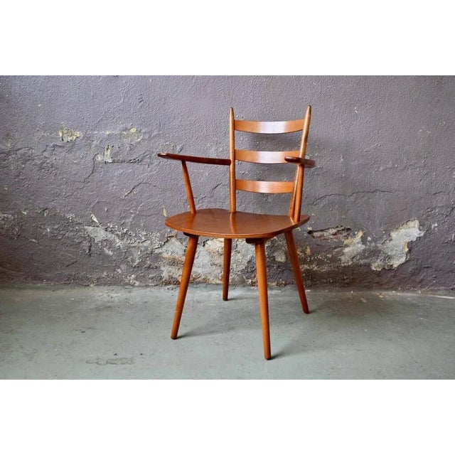 This pretty armchair made in beech and plywood of light honey shade has slender and voluntary lines, in a Scandinavian...