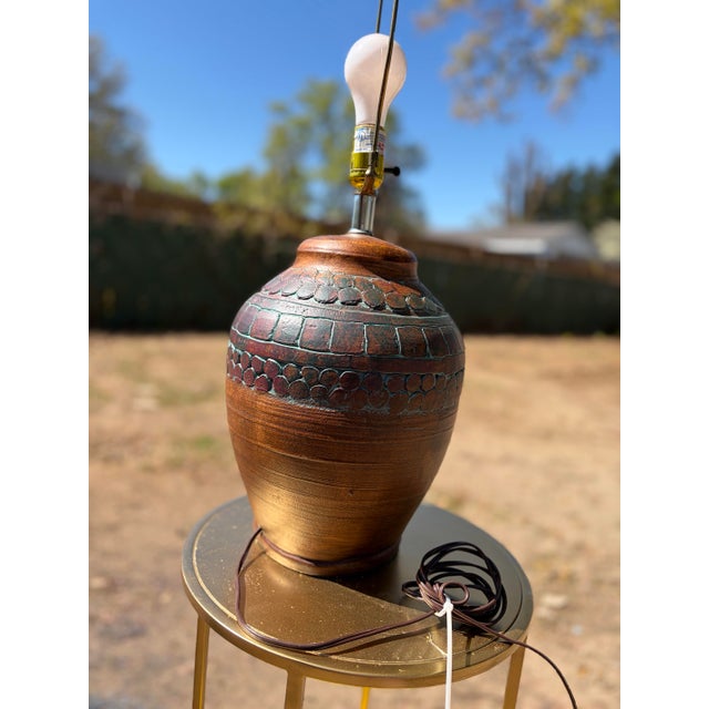 This is a vintage mid century ceramic table lamp by Elite, featuring a substantial urn-shaped base with carved geometric...