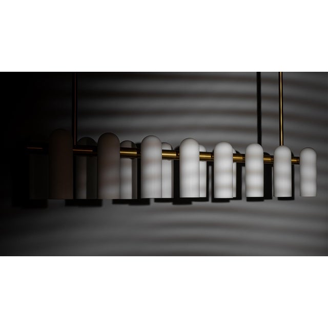 A colonnade of light sources. This delicate engine of frosted glass generates a luminous environment while contrasting...