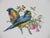 A Mottahedeh design plate decorated with two colorful parrots resting on a floral branch.