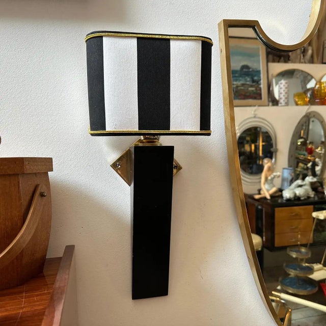 This is a 1980s Art Deco-inspired Italian wall sconce, combining a sleek and sophisticated aesthetic. The base is...