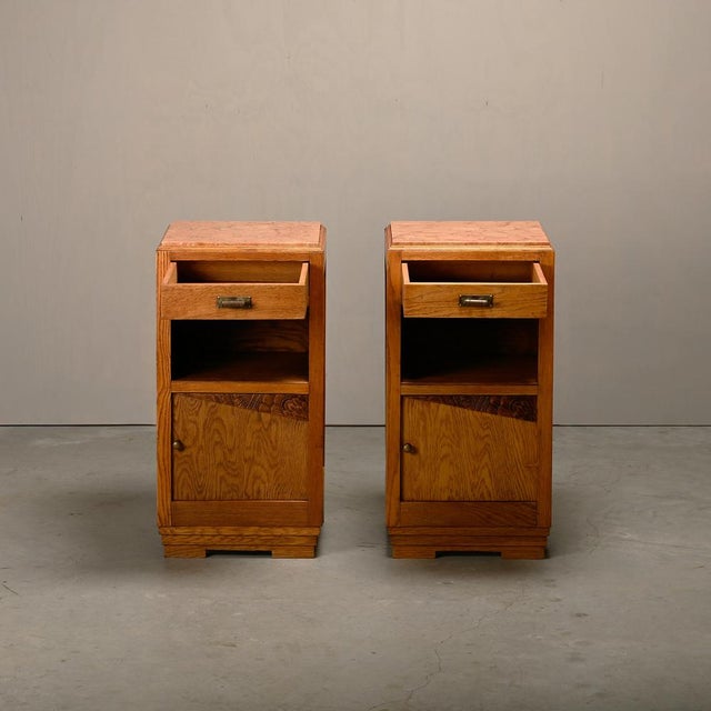 Elegant pair of Art Deco nightstands or bedside tables, France 1930s. Oak cabinets with marble tops in good original...