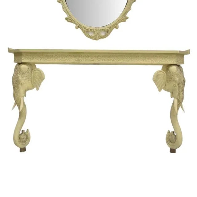 A painted and carved elephant console table and mirror set. Crafted with precision, the console table features legs of...