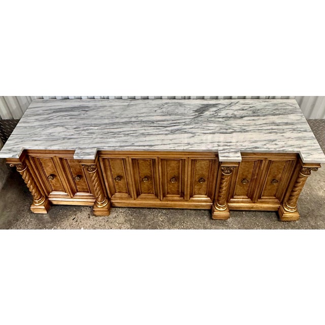 Gorgeous neoclassical low credenza features a striking marble top , carved Corinthian columns, intricate brass pulls and...