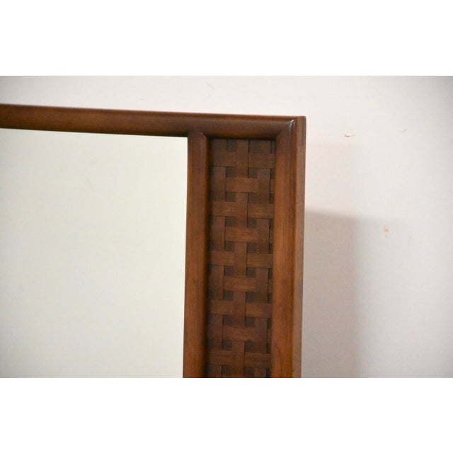 A mid century modern walnut mirror with the classic basket weave pattern made by Lane Perception. Unmarked.