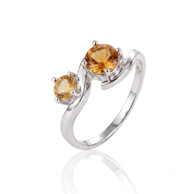 Radiating pure warmth, this organic bypass ring features a polished, fluid metal frame that hugs two glowing golden gems...